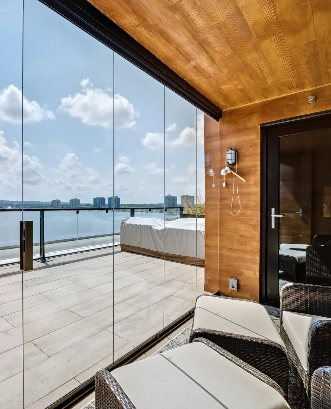 Condo balcony enclosed in frameless glass with an open water view