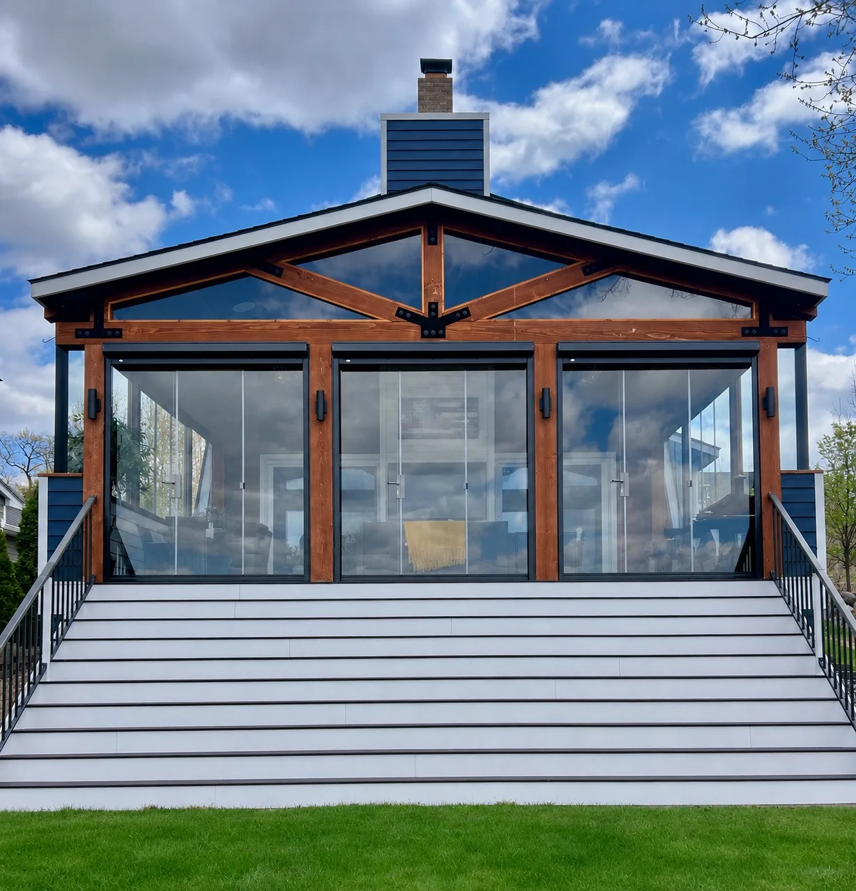 White gable pavilion enclosed in frameless glass above a wide stair