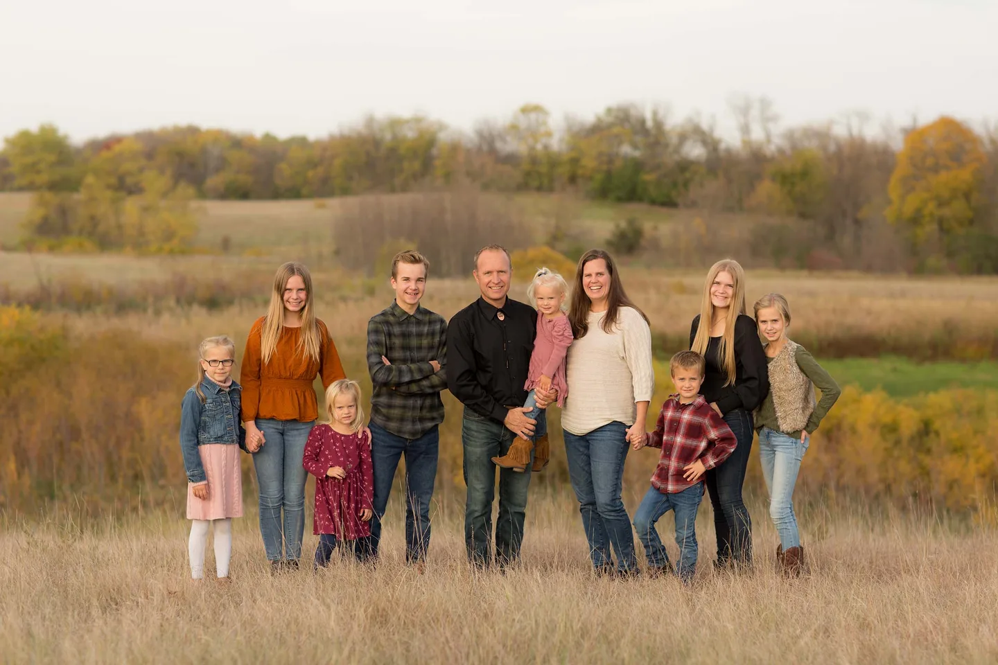 The Koski family of ten standing in a golden fall field