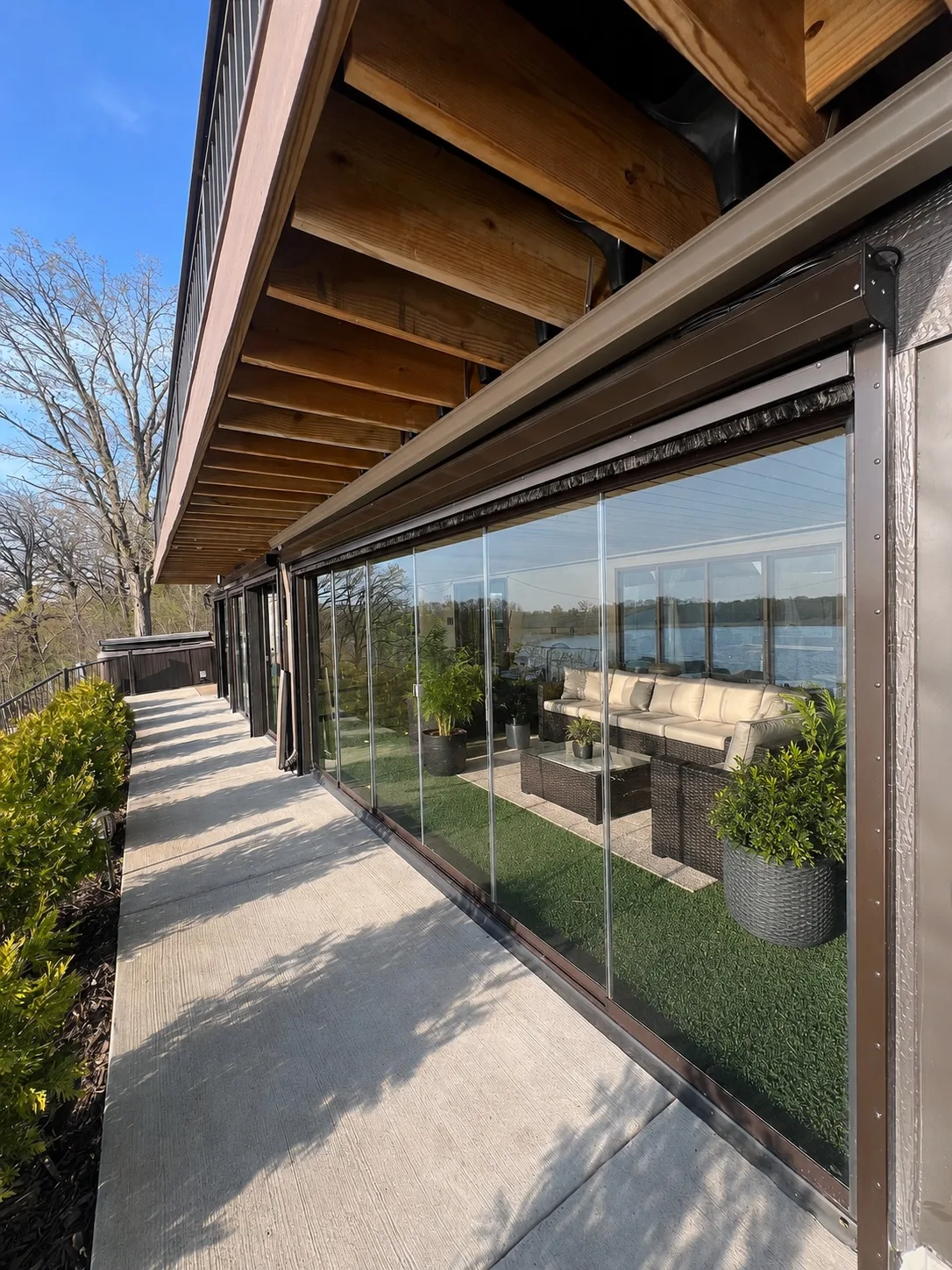 Long glazed porch with lounge seating and an open water view
