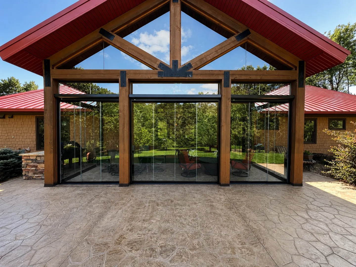 Red-roofed timber pavilion glazed with retractable glass panels