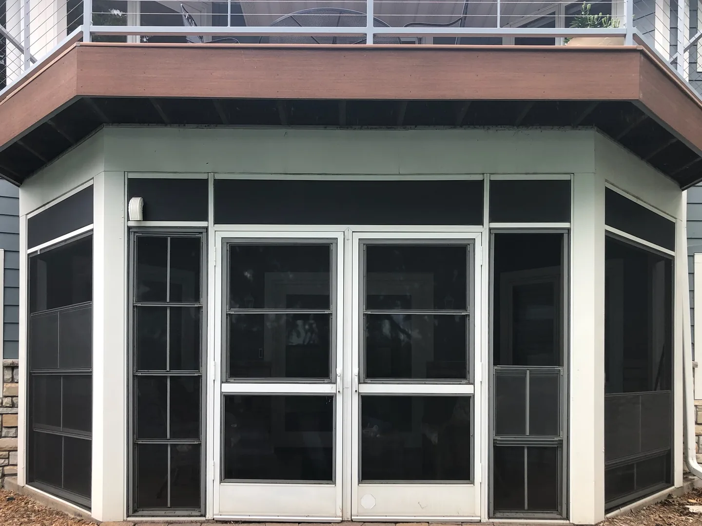 Porch with its original white-framed screens, dark and closed off