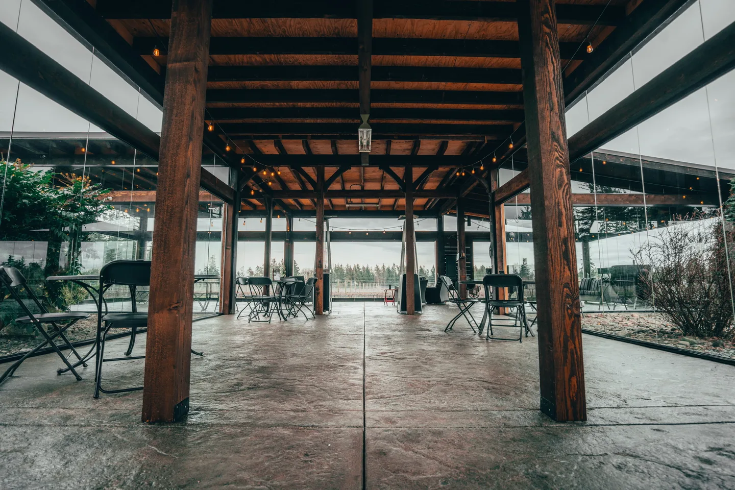 Under-deck room enclosed in glass between timber posts, lake beyond